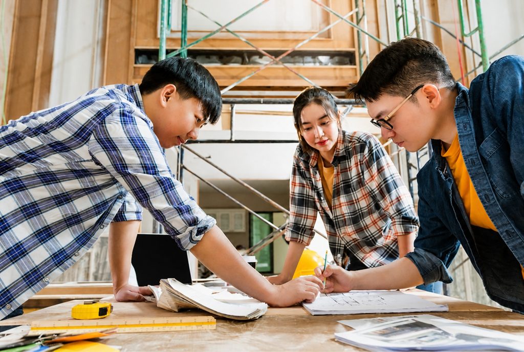 Engineering student in Malaysia reviewing structural blueprints during a university laboratory session
