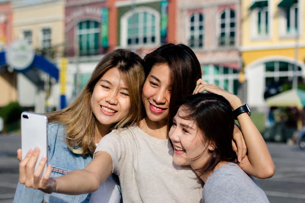 A diverse group of university students chatting and laughing together on campus, showing how making friends at university happens naturally